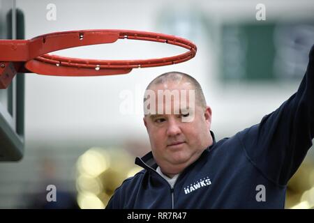 Coach participating in a traditional cutting down of the net following a regional championship game victory. USA. Stock Photo