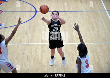 Player launching a jump shot from within some open space as two opponents close in on the effort. USA. Stock Photo