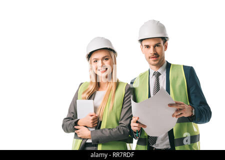 engineers in safety vests and hardhats holding digital tablet and blueprint, isolated on white Stock Photo