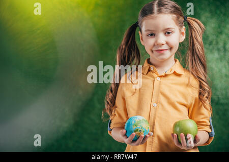 child holding globe model and apple on blurred background on blurred background, earth day concept Stock Photo