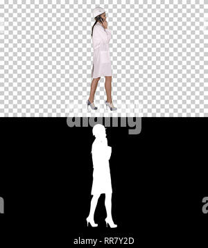 On Alpha Matte. Full length side view. Female science engineer making a call while walking, Alpha Channel. Professional shot in 4K resolution. 013. Yo Stock Photo