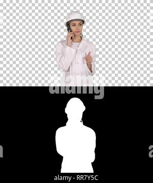 On Alpha Matte. Medium shot. Woman engineer talking on the phone while walking, Alpha Channel. Professional shot in 4K resolution. 013. You can use it Stock Photo