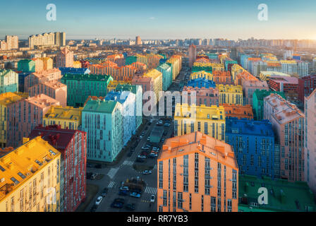 Aerial view of the colorful buildings in european city at sunset. Cityscape with multicolored houses, cars on the street in Kiev, Ukraine. Top view. U Stock Photo