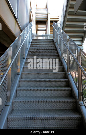 Looking up at some metal stairs on the exterior of a modern metallic building; Bryan, Texas, USA. Stock Photo