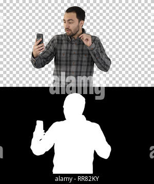 On Alpha Matte. Medium shot. Young blogger recording video on his phone while walking, Alpha Channel Professional shot in 4K resolution. 004. You can  Stock Photo