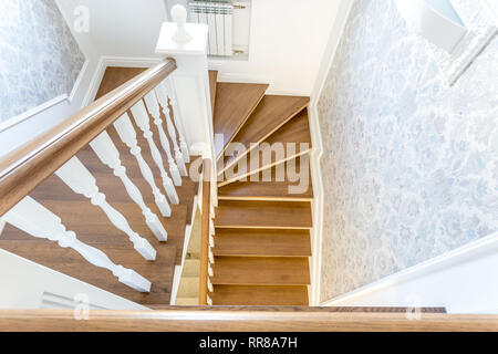 wooden spiral staircase in bright interior in vacation house Stock Photo