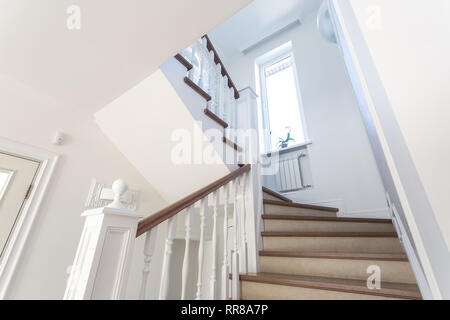 wooden spiral staircase in bright interior in vacation house Stock Photo