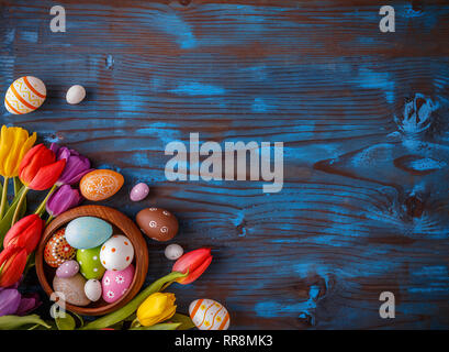 Easter still life with spring flowers and copy space on blue wooden board Stock Photo