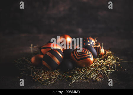 Easter greeting card. Black and golden eggs with stripes and dots on black background Stock Photo