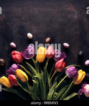 Easter holiday background with Easter eggs and tulip flowers. Top view and copy space Stock Photo