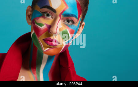 Colorful, creative and artistic pop art make up. Beautiful model looking at camera, posing. Funky and stylish woman has plump lips with pink lipstick. Stock Photo
