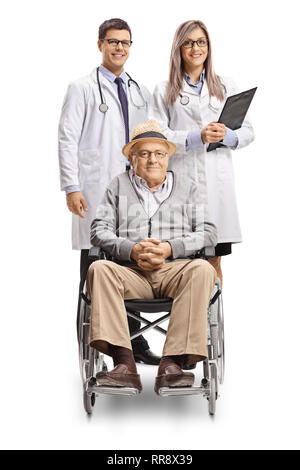 Disabled senior man in a wheelchair and a male and female doctor standing behind him isolated on white background Stock Photo