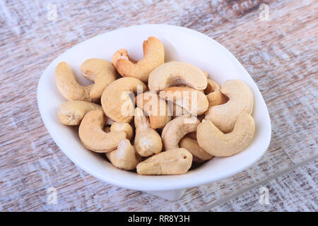nuts cashews in white bowl on wooden background. Selective focus. Stock Photo