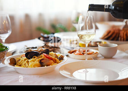 People fine dining seafood and white wine on the table at home Stock Photo