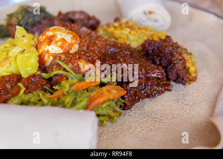 African food.  Chicken, egg Doro Wat, berbere, lentils and Injera, the national dish of Ethiopia, is a sourdough flatbread made from teff flour Stock Photo