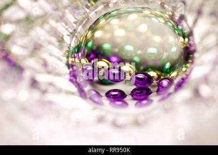 Macro art abstract of traditional three color Mardi Gras beads in a frosted lead crystal glass bowl Stock Photo