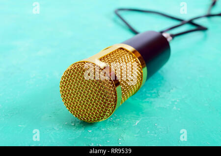 Beautiful golden microphone on a bright background, close up, bokeh. Stock Photo