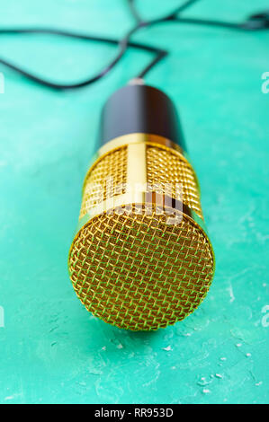 Beautiful golden microphone on a bright background, close up, bokeh. Stock Photo