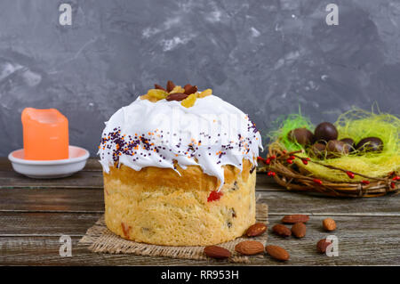Easter cakes, painted eggs, chocolate sweets, and other attributes of Easter. Sweet festive bread with meringue cream. Stock Photo