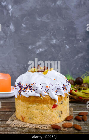 Easter cakes, painted eggs, chocolate sweets, and other attributes of Easter. Sweet festive bread with meringue cream. Stock Photo