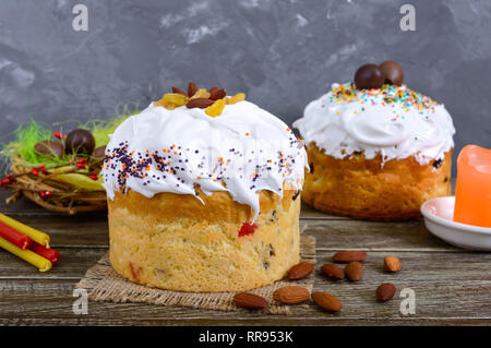 Easter cakes, painted eggs, chocolate sweets, and other attributes of Easter. Sweet festive bread with meringue cream. Stock Photo