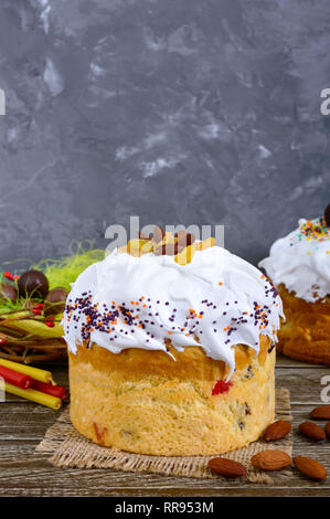 Easter cakes, painted eggs, chocolate sweets, and other attributes of Easter. Sweet festive bread with meringue cream. Stock Photo