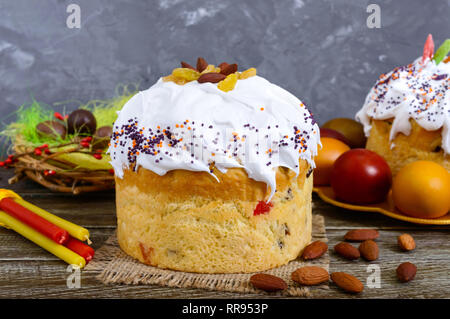 Easter cakes, painted eggs, chocolate sweets, and other attributes of Easter. Sweet festive bread with meringue cream. Stock Photo