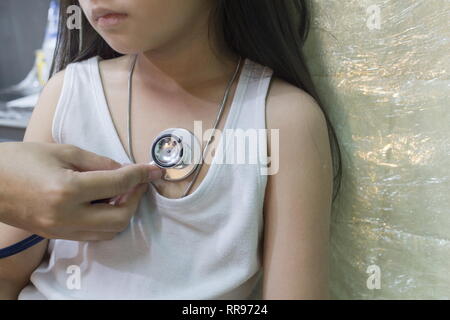 The Doctor examining asian girl and listen heartbeat with stethoscope in the hospital. Stock Photo