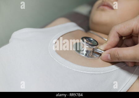 The Doctor examining asian girl and listen heartbeat with stethoscope in the hospital. Stock Photo