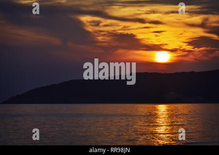 Moody golden sunset over the sea after a hot summer day Stock Photo