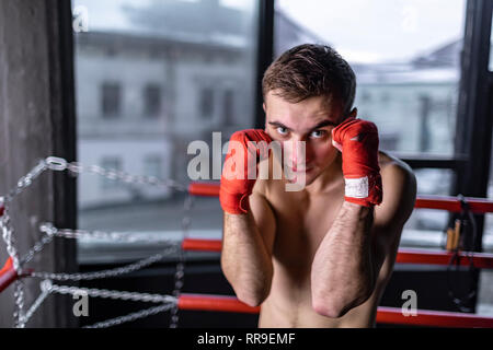 Boxing man with red bandages in the ring Stock Photo