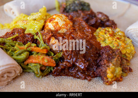 African food.  Chicken, egg Doro Wat, berbere, lentils and Injera, the national dish of Ethiopia, is a sourdough flatbread made from teff flour Stock Photo