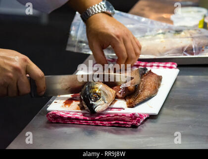 Chef cutting fish, Chef slices fish fresh on Board in the kitchen Stock Photo