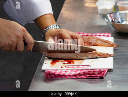 Chef cutting fish, Chef slices fish fresh on Board in the kitchen Stock Photo