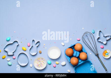 Easter Concept, Cookie Cutters, Eggs, Sugar Sprinkles and Chocolate Eggs on Bright Background, Top View Stock Photo