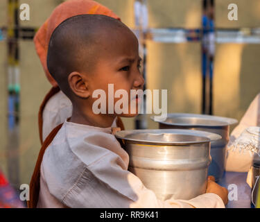 Buddhist young nun asks for offerings in the morning, Yangon, Myanmar Stock Photo