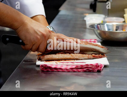 Chef cutting fish, Chef slices fish fresh on Board in the kitchen Stock Photo