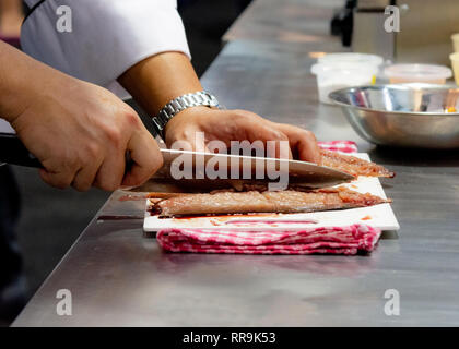 Chef cutting fish, Chef slices fish fresh on Board in the kitchen Stock Photo