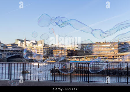 LONDON, UK – Dec 13, 2018: Performer blowing soup bubbles on beautiful sunny day on the bank of River Thames London Stock Photo