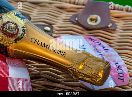 ROYAL ASCOT RACES PICNIC Champagne bottle on wicker picnic hamper with Ascot Royal Enclosure ticket pass Stock Photo