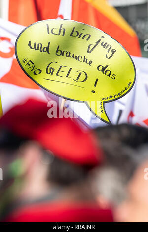 Stuttgart, Germany. 25th Feb, 2019. A participant in a warning strike in the dispute over the tariff for civil servants in the Länder holds up a sign with the inscription 'I am young and need the money'. The unions demand six percent more money for the employees, but at least 200 euros more per month. Credit: Sebastian Gollnow/dpa/Alamy Live News Stock Photo