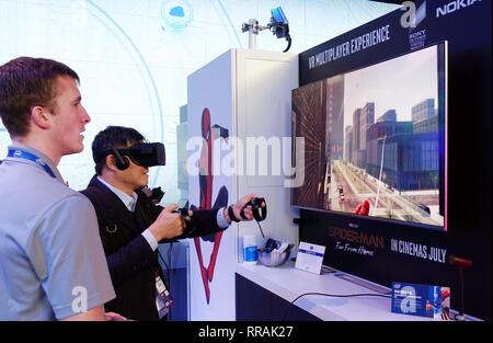 Barcelona, Spain. 25th Feb, 2019. A visitor plays VR games at the 2019 Mobile World Congress (MWC) in Barcelona, Spain, Feb. 25, 2019. The four-day 2019 MWC opened on Monday in Barcelona. Credit: Guo Qiuda/Xinhua/Alamy Live News Stock Photo