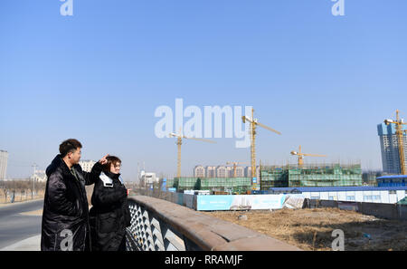 (190225) -- TIANJIN, Feb. 25, 2019 (Xinhua) -- Zhang Shiyu (R) and Lyu Xin watch their wedding house under construction in north China's Tianjin, Feb. 1, 2019. Zhang Shiyu and Lyu Xin got married in 2018. Although the couple work in Beijing, they chose to buy their wedding house in the neighboring Tianjin City,where Zhang Shiyu was born, given the convenience brought by the Beijing-Tianjin-Hebei integration. They now go to Tianjin every two weeks and return to Beijing on Sunday nights. Thanks to the development of Beijing, Tianjin and Hebei Province -- a regional city cluster called 'Jing-jin- Stock Photo