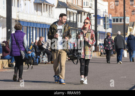 Sidmouth, Devon, UK.  25th February 2019. UK Weather.  A couple walking along on the seafront at Sidmouth in Devon as the unseasonably warm sunny weather continues.   Picture Credit: Graham Hunt/Ģ����ý Live News Stock Photo