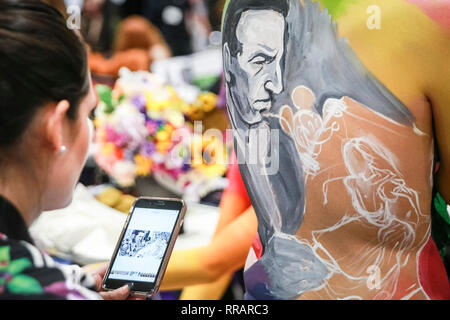 Excel, London, UK. 25th Feb, 2019. Make-up artist 'Mishel' applies makeup to a model in the Walt Disney category of the Warpaint competition. The design features a picture of Walt Disney painted from a photograph. The Professional Beauty London show brings together hair and beauty practitioners, cosmetics and aesthetics professionals, and representatives from over 800 brands with those interested in hair and beauty in the UK's biggest industry event at ExCel London Exhibition Centre. Credit: Imageplotter/Alamy Live News Stock Photo