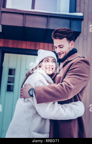 Dark-haired husband wearing brown coat loving his woman greatly Stock Photo