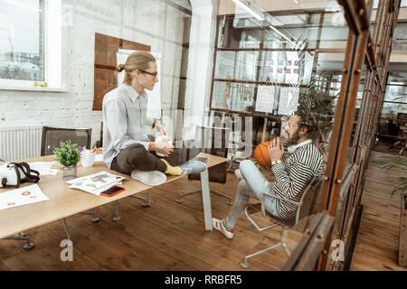 Pleasant young man sitting on the table Stock Photo