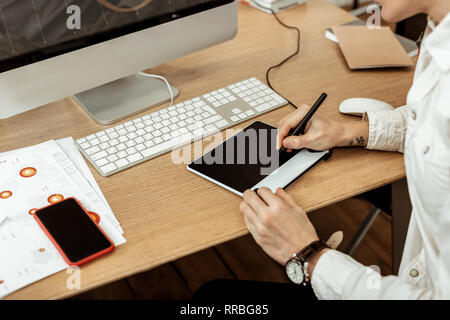Pleasant young man using a graphic tab Stock Photo