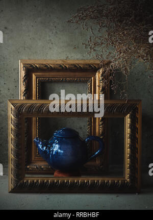 Side view on Side view ceramic blue tea pot looking like a painting in picture frames Stock Photo