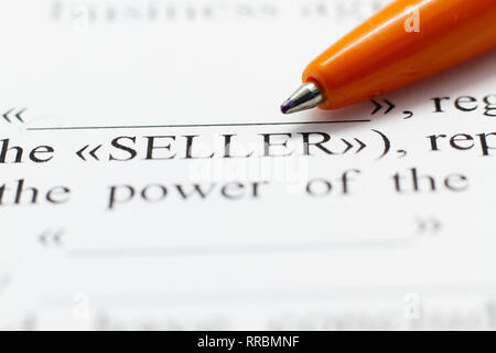 Fragment of a contract printed on paper with a ballpoint pen. Macrophoto Word Seller close-up. The buyer and the seller made a contract on paper. Stock Photo